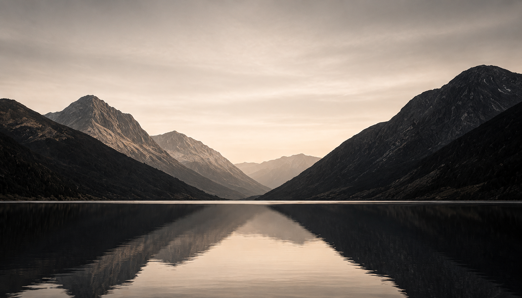 Mountain valley reflected in a calm lake at dusk